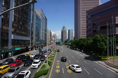 Traffic on city street amidst buildings against sky