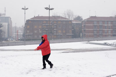 Full length of woman enjoying on snow covered field