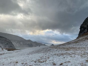 Scenic view of snow covered land against sky