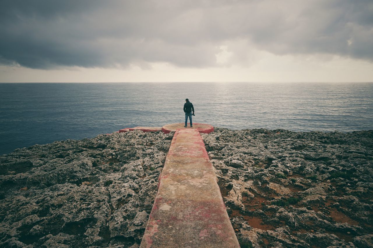 sky, sea, horizon over water, water, standing, lifestyles, rear view, tranquil scene, cloud - sky, tranquility, men, leisure activity, scenics, beauty in nature, nature, cloud, person, idyllic