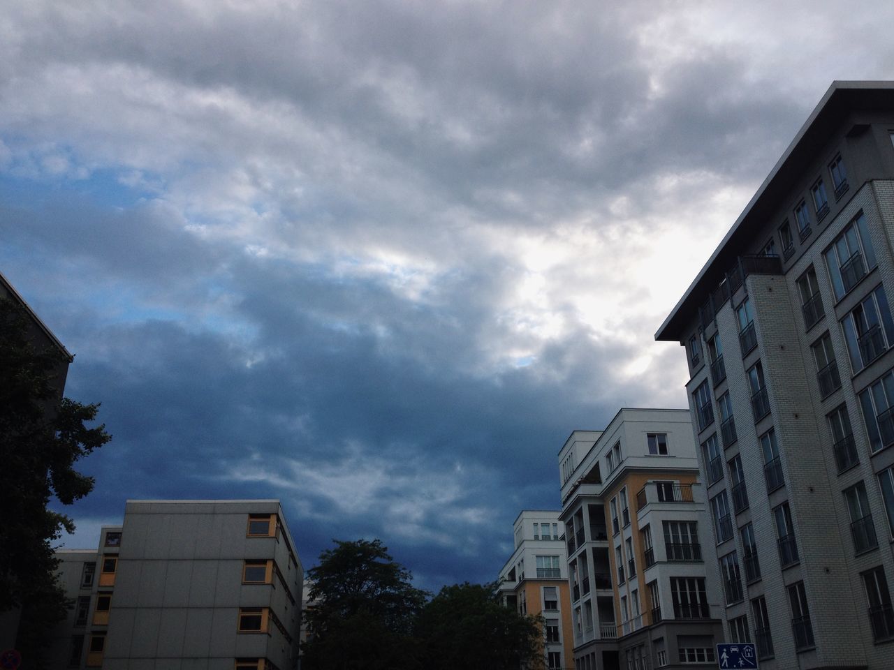 building exterior, architecture, built structure, sky, low angle view, cloud - sky, cloudy, city, residential building, building, residential structure, cloud, overcast, weather, tree, house, outdoors, no people, day, apartment