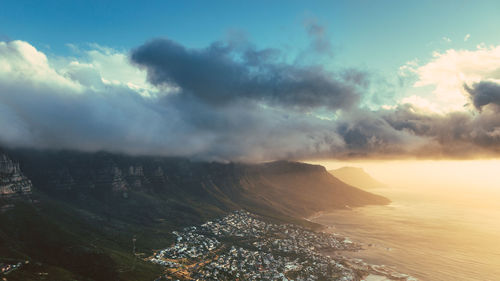 Aerial view of city by sea against sky