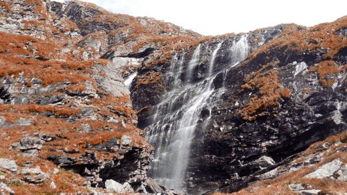 Scenic view of waterfall against sky