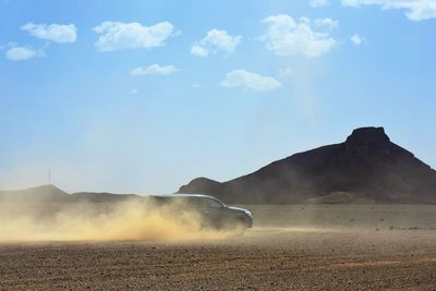Powerful land vehicle in motion on a deserted dusty ground