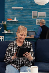 Young woman using mobile phone while sitting at home