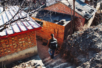 Rear view of man walking by building