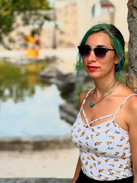 Portrait of young woman wearing sunglasses standing outdoors