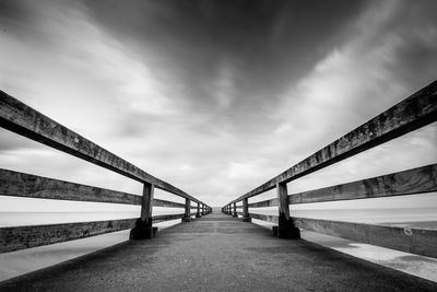 Bridge over calm sea against sky