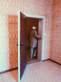 Rear view of man standing by door