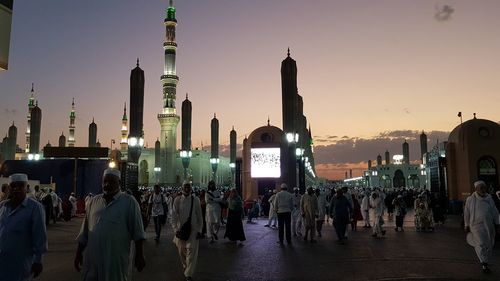 Group of people in front of buildings at sunset