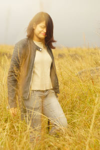 Young woman walking amidst plants during sunset