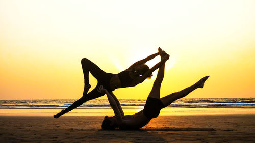 Silhouette man on beach against sky during sunset