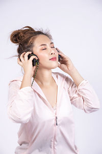 Young woman looking away against white background