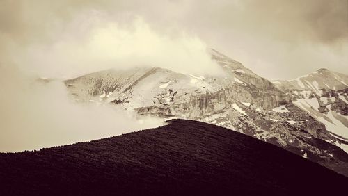 Scenic view of mountains against cloudy sky