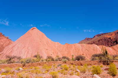 Scenic view of desert against blue sky