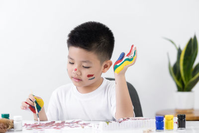 Portrait of boy holding ice cream on table