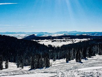 Scenic view of snowcapped mountains against blue sky