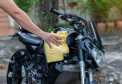 Biker man cleaning motorcycle , polished on fuel tank in laundry area.