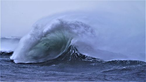 Water splashing in sea against sky