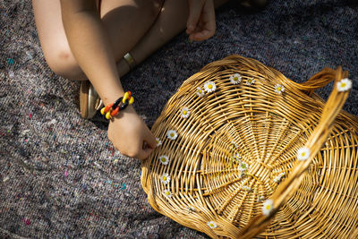 Portrait of a girl decorating a basket with daisies on a summer day.