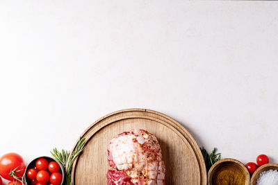 Directly above shot of meat with ingredients on white background