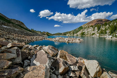 Scenic view of lake by mountain against sky