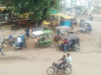 People riding motor scooter on road