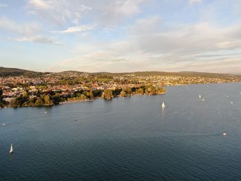 High angle view of townscape by sea against sky