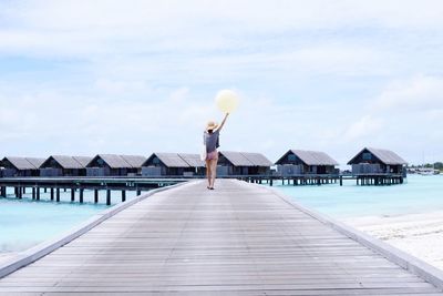 Woman jumping on pier