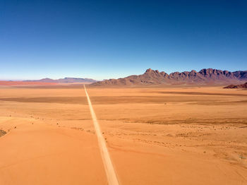 Scenic view of desert against clear blue sky