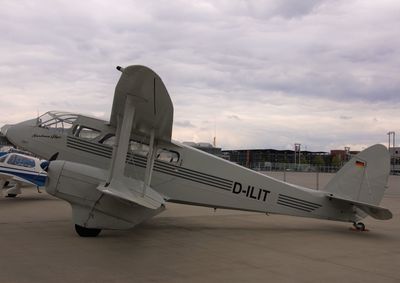 Side view of airplane on airport runway against sky