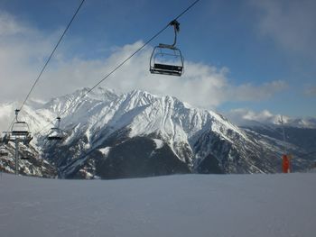 Overhead cable car over snowcapped mountains against sky