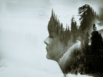 Portrait of man looking at tree against sky