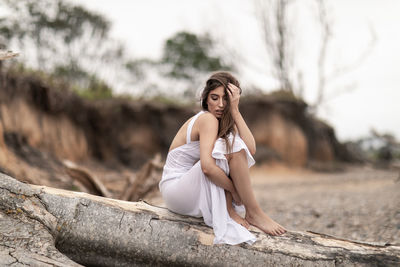 Young woman sitting on wood