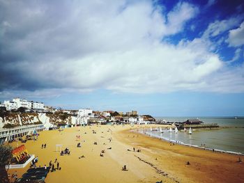 Panoramic view of people on beach against sky