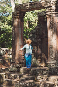 Rear view of woman standing at historical building