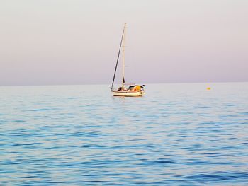 Sailboat sailing on sea against sky