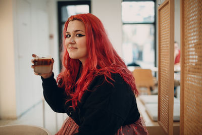 Portrait of young woman drinking outdoors