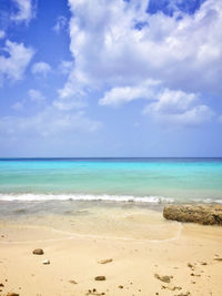 Scenic view of beach against cloudy sky