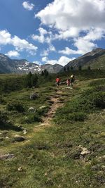 People walking on mountain against sky