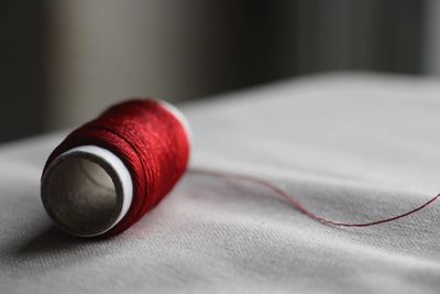 Close-up of red thread spool on fabric