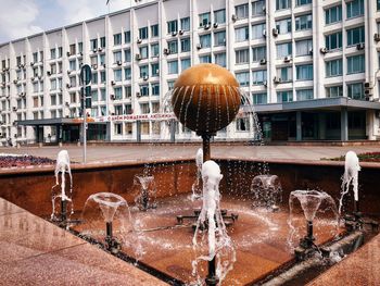 View of fountain against buildings in city