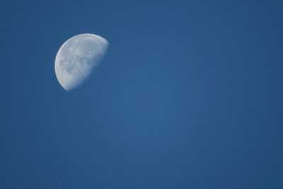 Low angle view of moon against blue sky