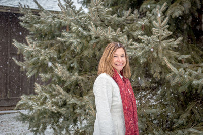 Portrait of smiling woman standing in snow