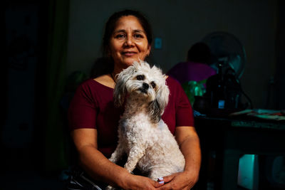 Portrait of adult woman holding her dog