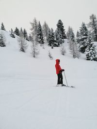 Full length of woman skiing on snow covered field