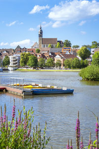 Scenic view of river by buildings in city against sky