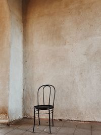 Empty chair against wall