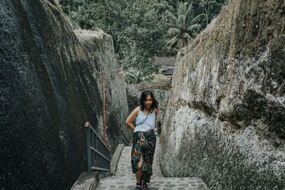 Full length of woman standing against wall