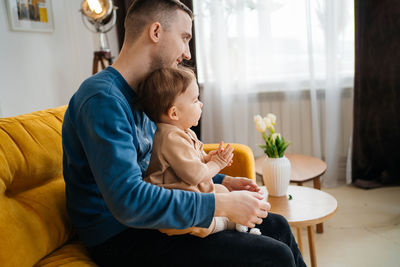 Side view of boy using laptop at home